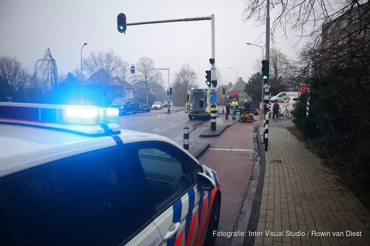 Fietser rijdt door rood en schrikt van auto uit uitrit