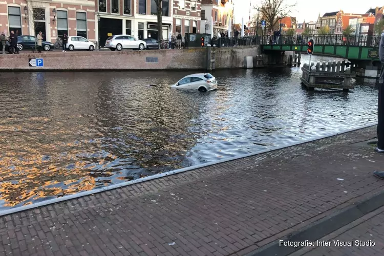 Auto drijft in Spaarne in Haarlem